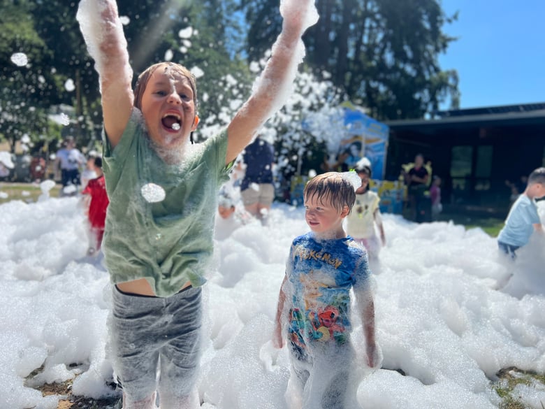 Students playing outside in a cloud of bubbles