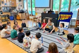Students listening to a teacher during a classroom music circle
